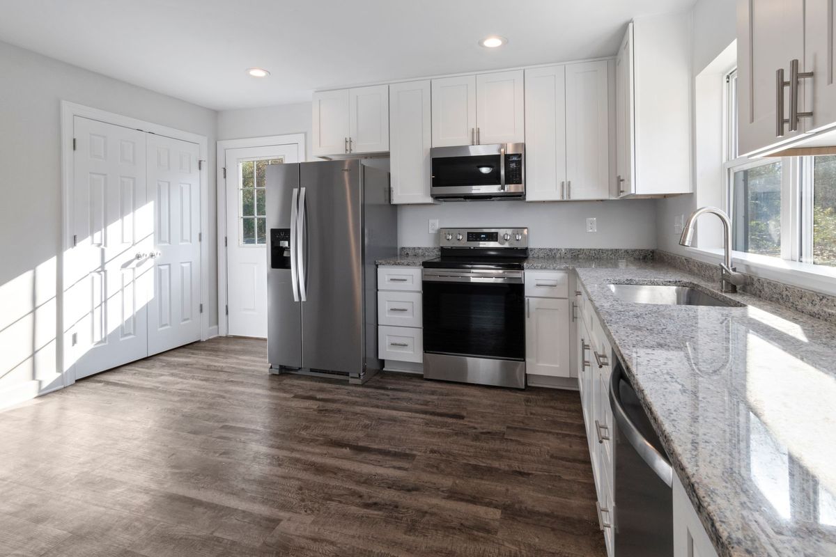 Cocina reformada con muebles claros y encimera de madera